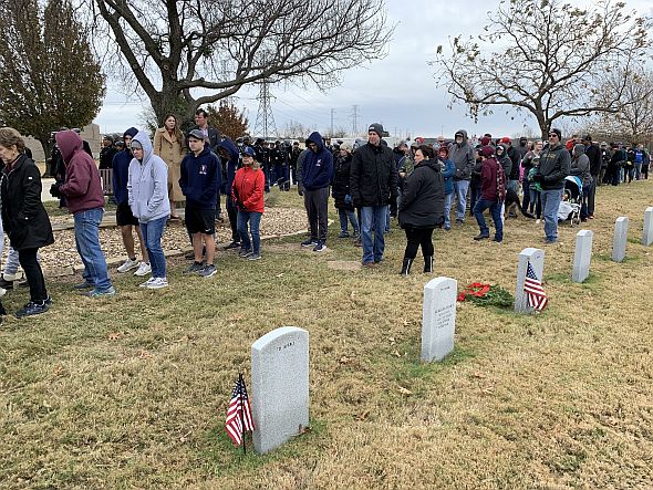 Despite cold and a persistent wind, thousands of volunteers lined up at DFW National Cemetery to place wreaths on National Wreaths Across America Day.