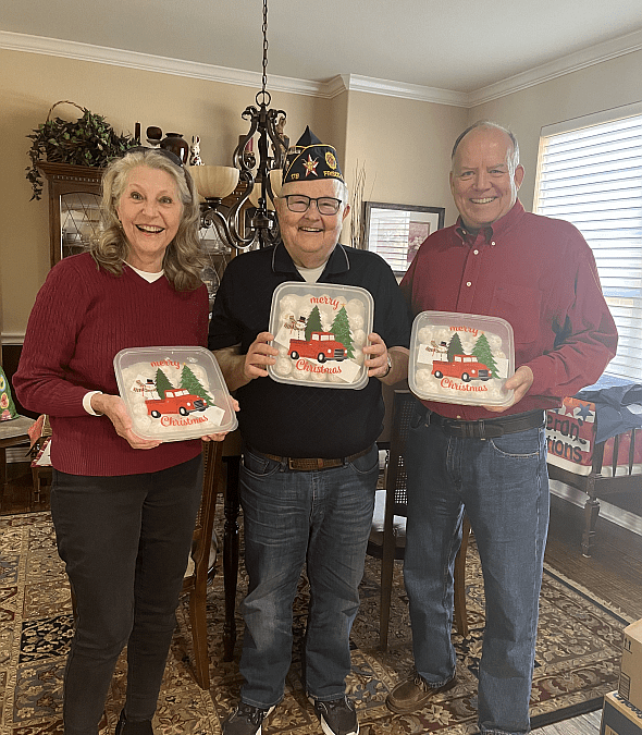 John Allen (center) helps Deborah and Scott Dillingham display hundreds of cookies they baked and donated to the Bonham Home Veterans.